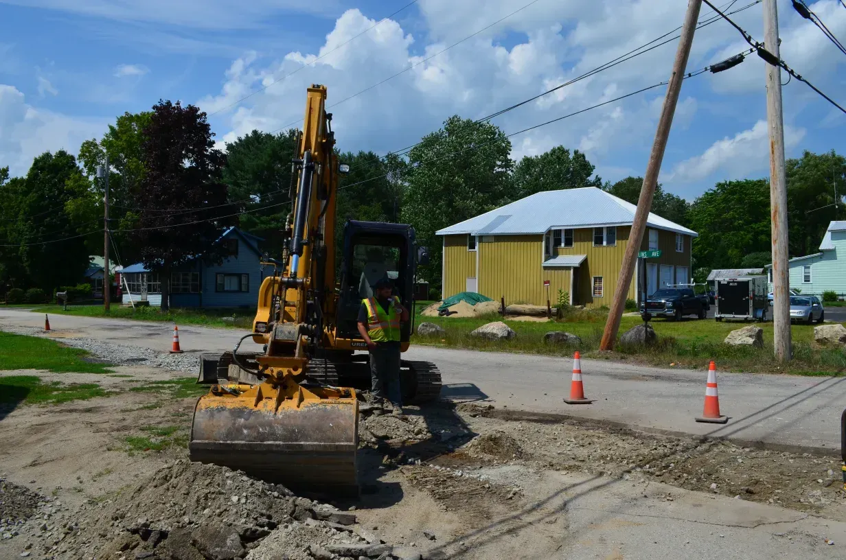 A yellow excavator is parked on the side of the road