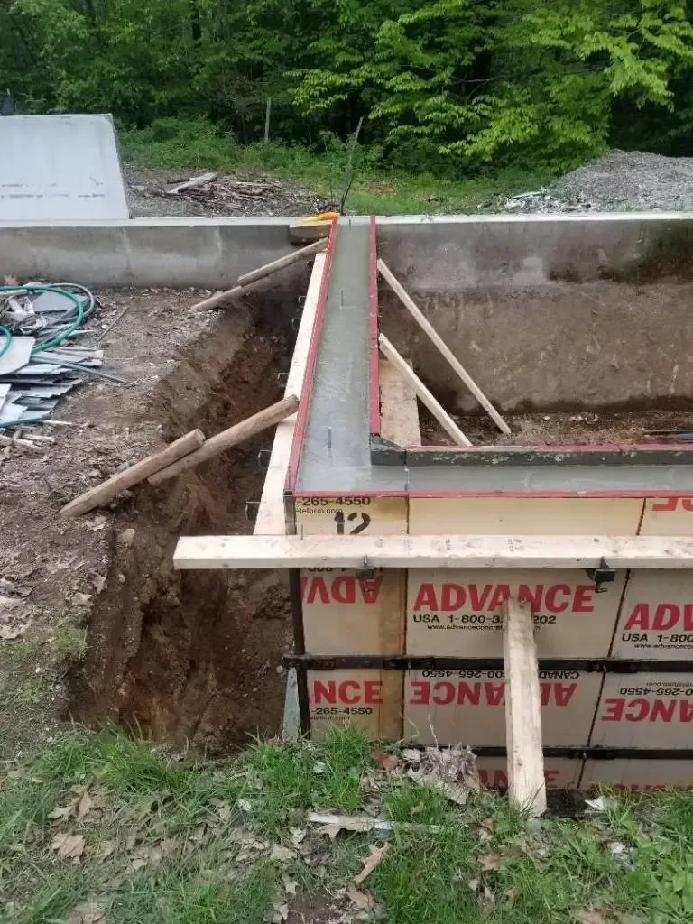A concrete wall is being built in a hole in the ground.