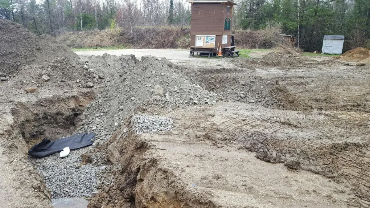 A large pile of dirt is sitting in the middle of a dirt field.