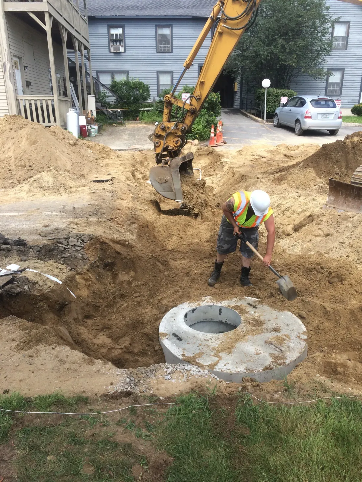 A man is digging a hole in the ground with a shovel.
