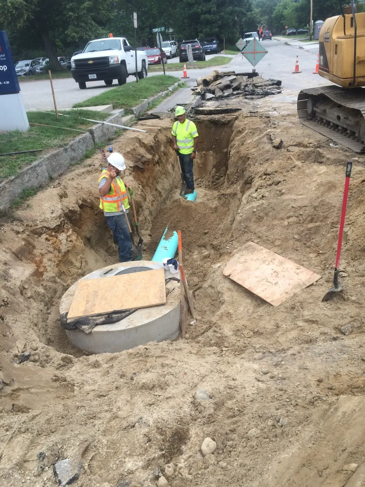 A group of construction workers are digging a hole in the ground.