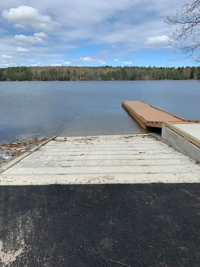 A dock with a ramp leading to a lake
