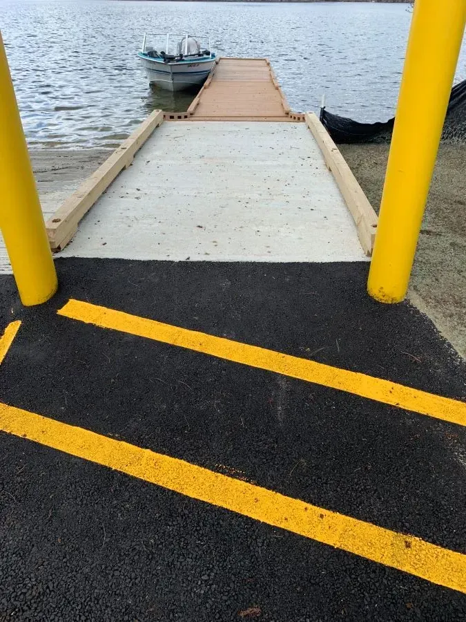 A ramp leading to a dock with a boat in the water