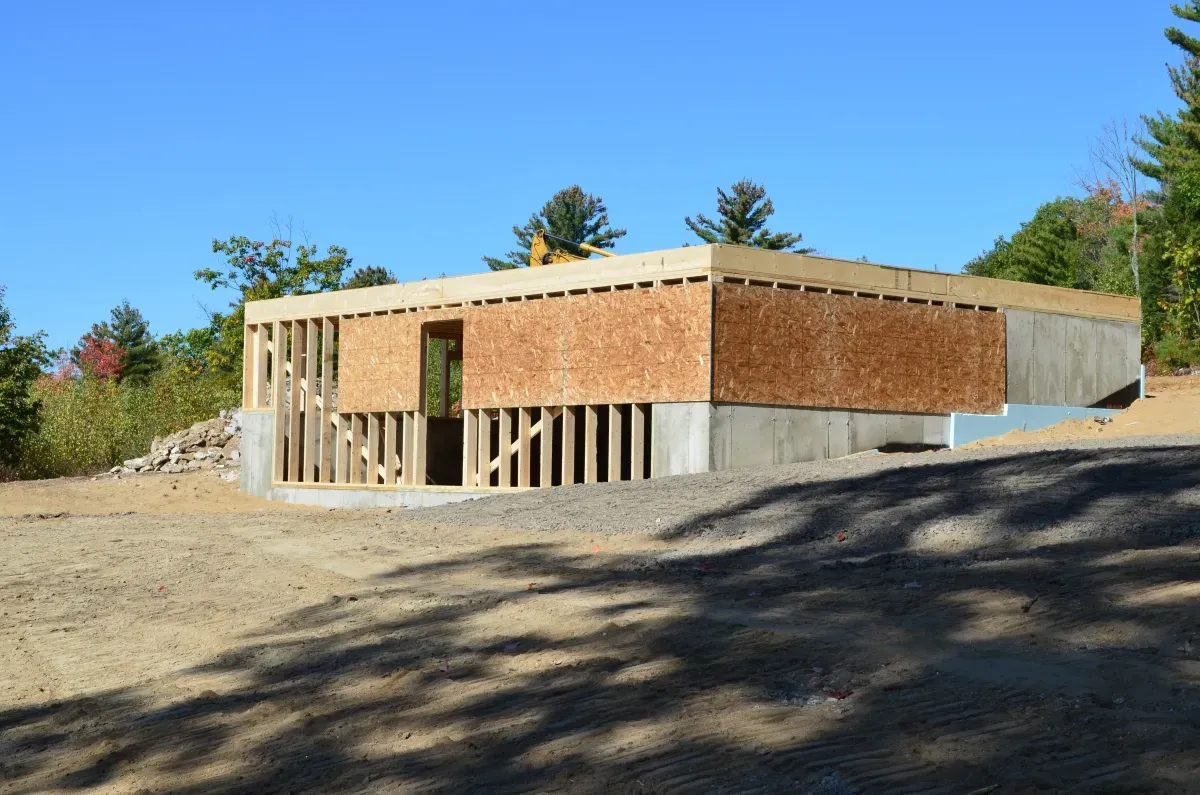 A house is being built in the middle of a dirt field.
