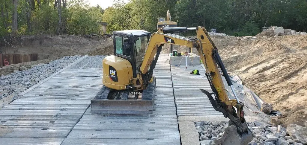 A yellow excavator is digging in the dirt on a construction site.