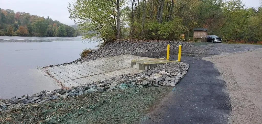 A car is parked on the side of a road next to a body of water.