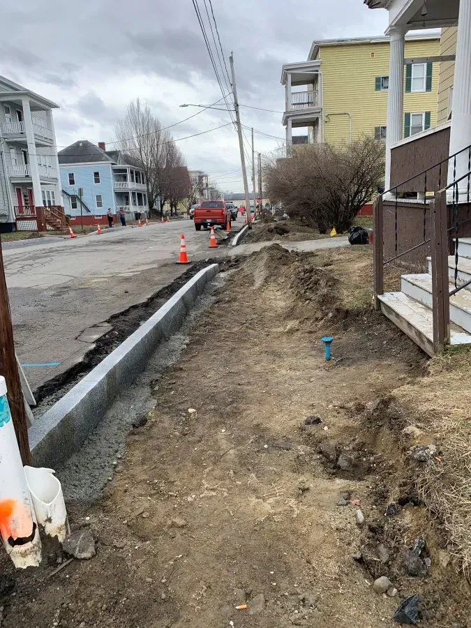A sidewalk is being built on the side of a street.