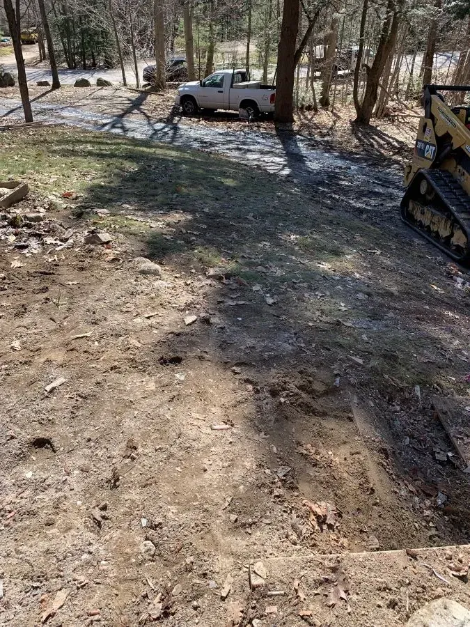 A white truck is parked in the dirt next to a bulldozer.