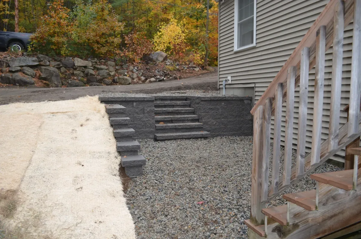 Stairs leading up to a house with a car parked in the background