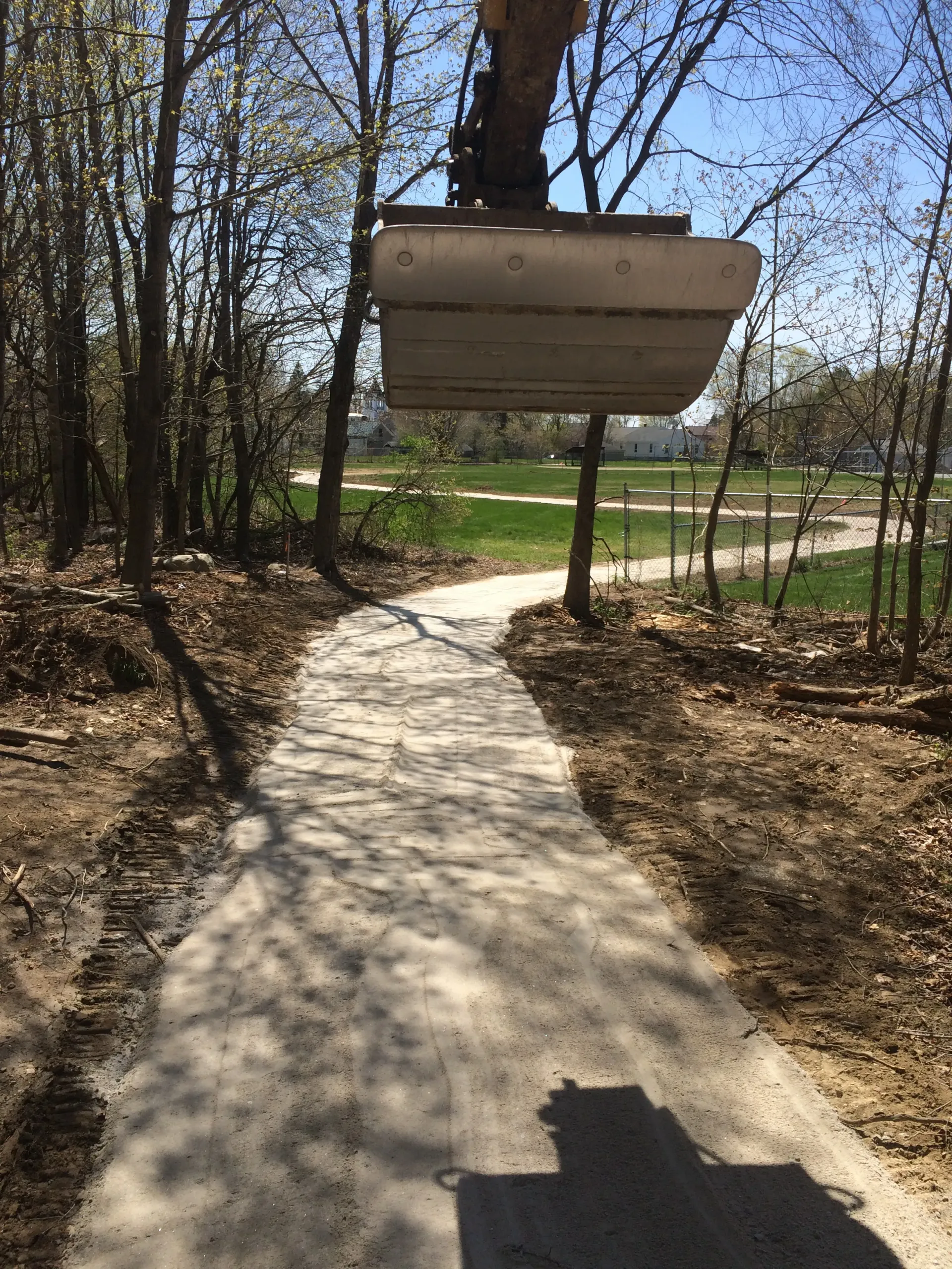 A large excavator is digging a path in the woods.