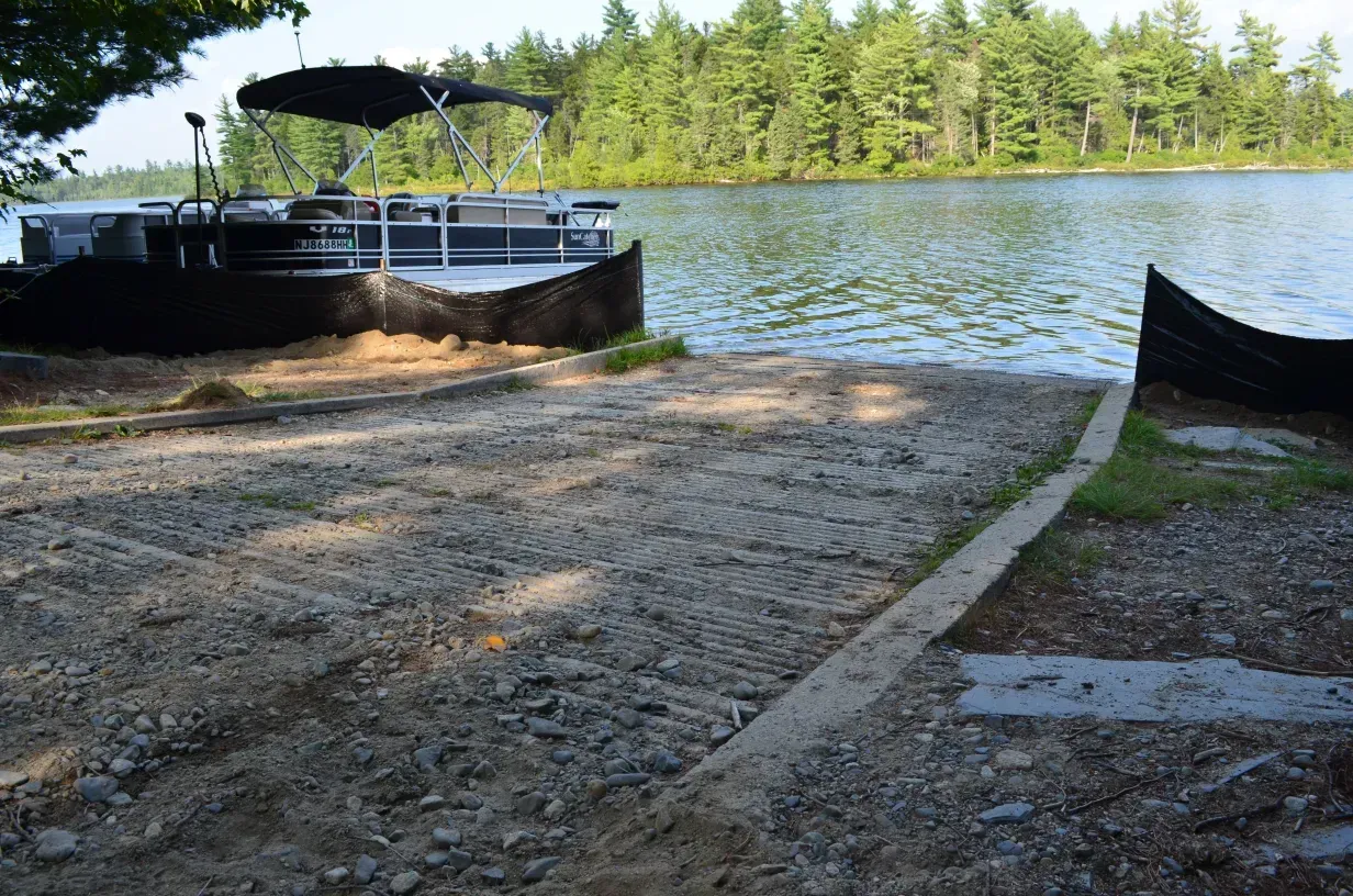 A boat is docked on the shore of a lake