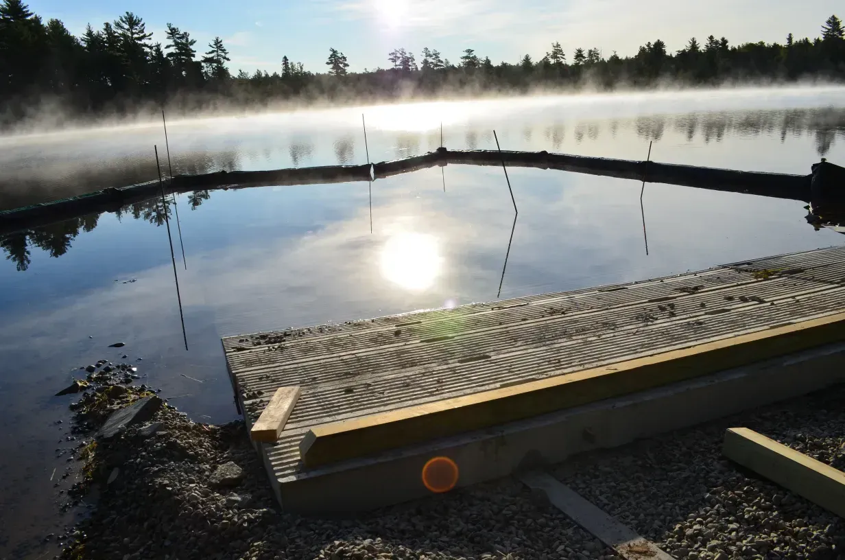 A foggy lake with a dock in the foreground