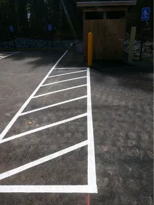 A parking lot with a handicapped parking space and a handicapped sign.
