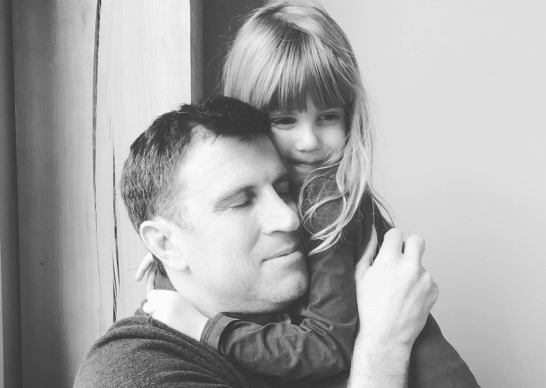 Aaron hugs his daughter who has CF - black and white photo. 