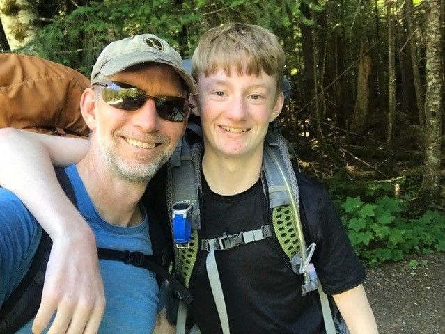 Father and son taking a selfie in the forest. 
