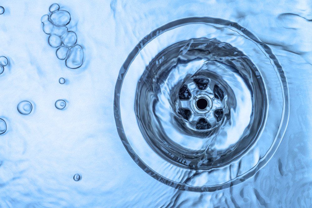 A close up of a drain with water running down it.