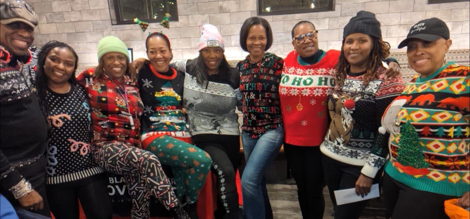 A group of people wearing christmas sweaters are posing for a picture.