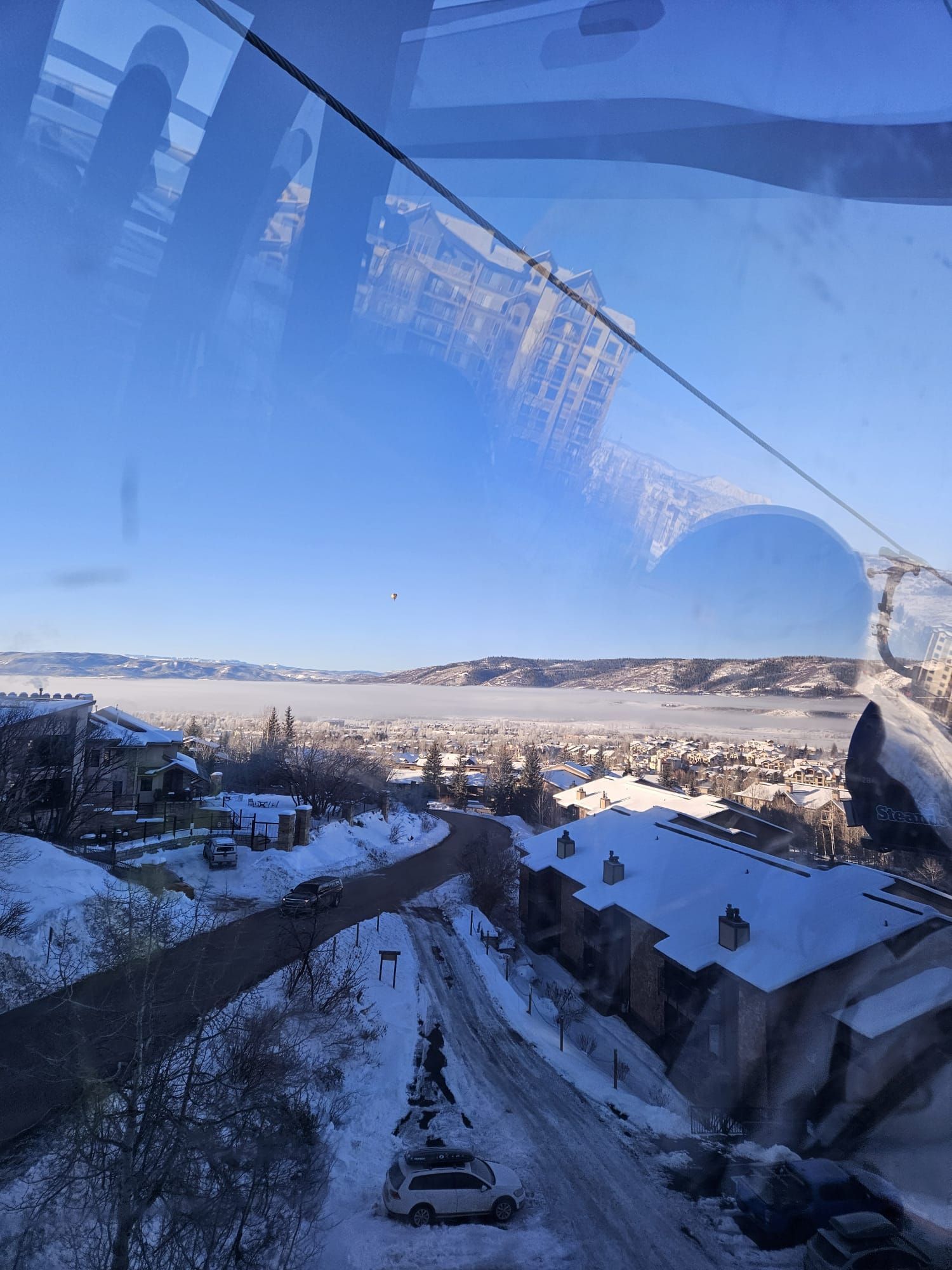 A view of a snowy city from a ski lift.