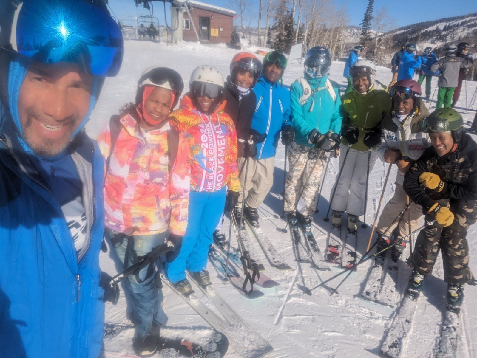 A group of skiers are posing for a picture on a snowy slope.
