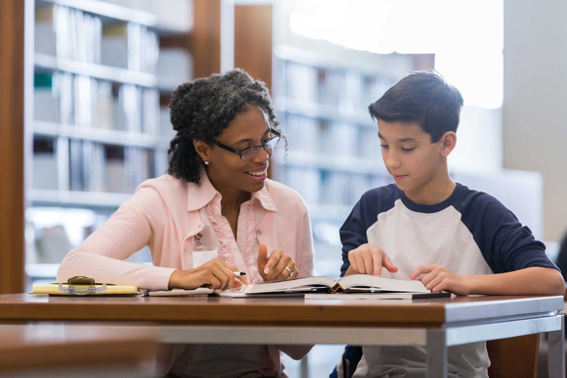 Female Tutor Helping Student in the Library — Panama City Beach, FL — Eselin Educational Services
