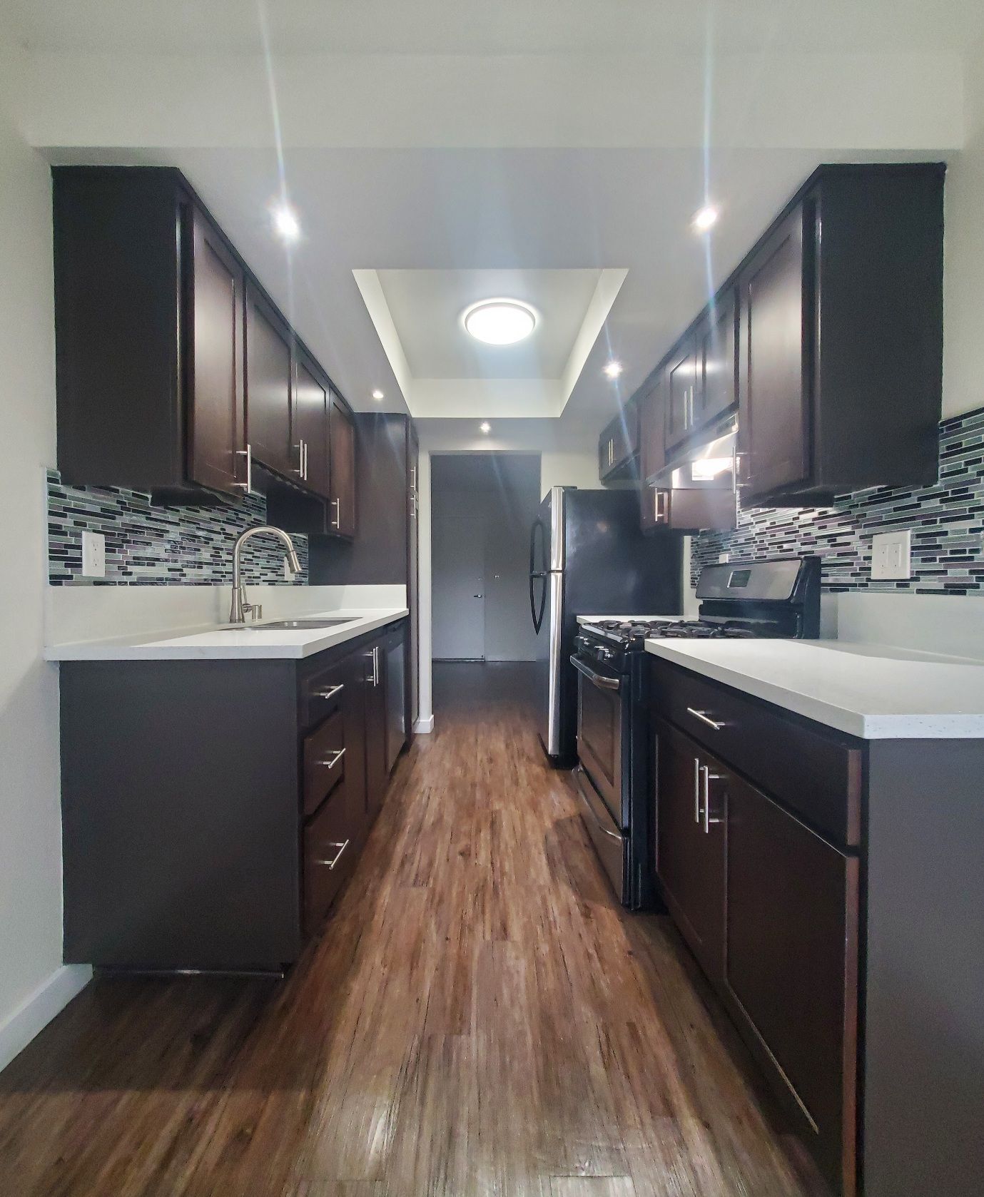 A kitchen with brown cabinets and white counter tops