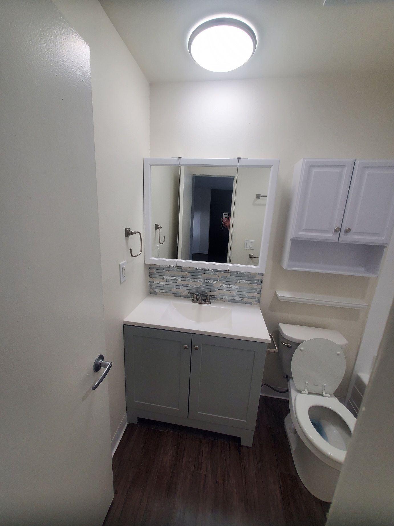 A bathroom with a sink , toilet and mirror.