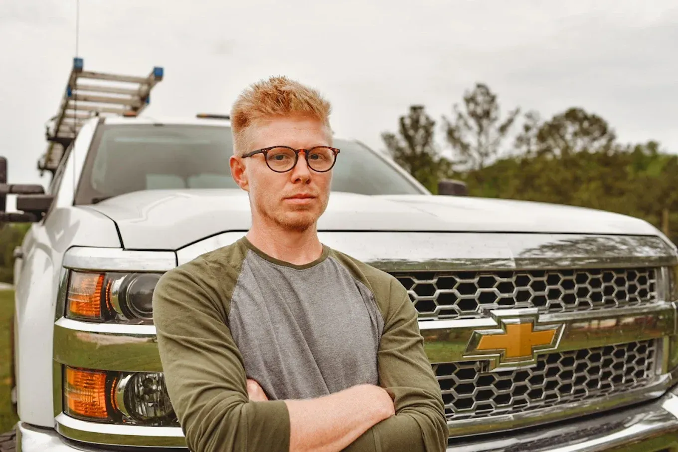 Group of women in pink shirts holding cleaning supplies smiling with a harbor background.