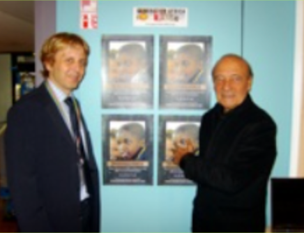 Man in suit poses with two Black people outdoors.