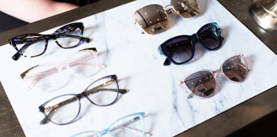 A table with glasses and sunglasses on it.