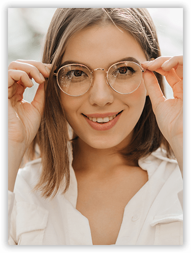 A woman wearing glasses is smiling and looking at the camera.