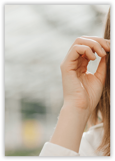 A woman is covering her face with her hand.