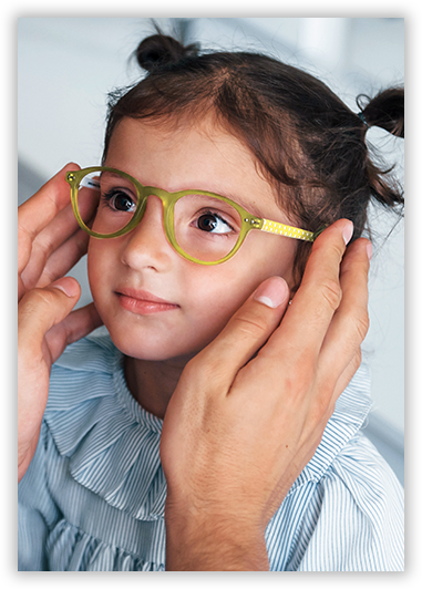 A little girl wearing glasses is being held by a man