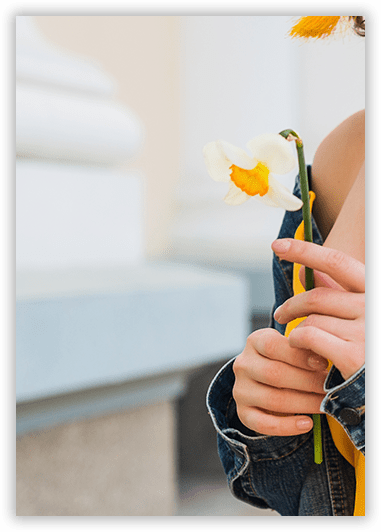 A person is holding a white flower with a yellow center