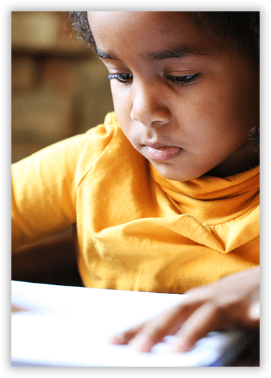 A young girl in a yellow shirt is using a tablet