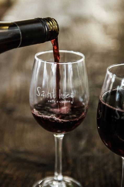 A bottle of wine is being poured into a wine glass.