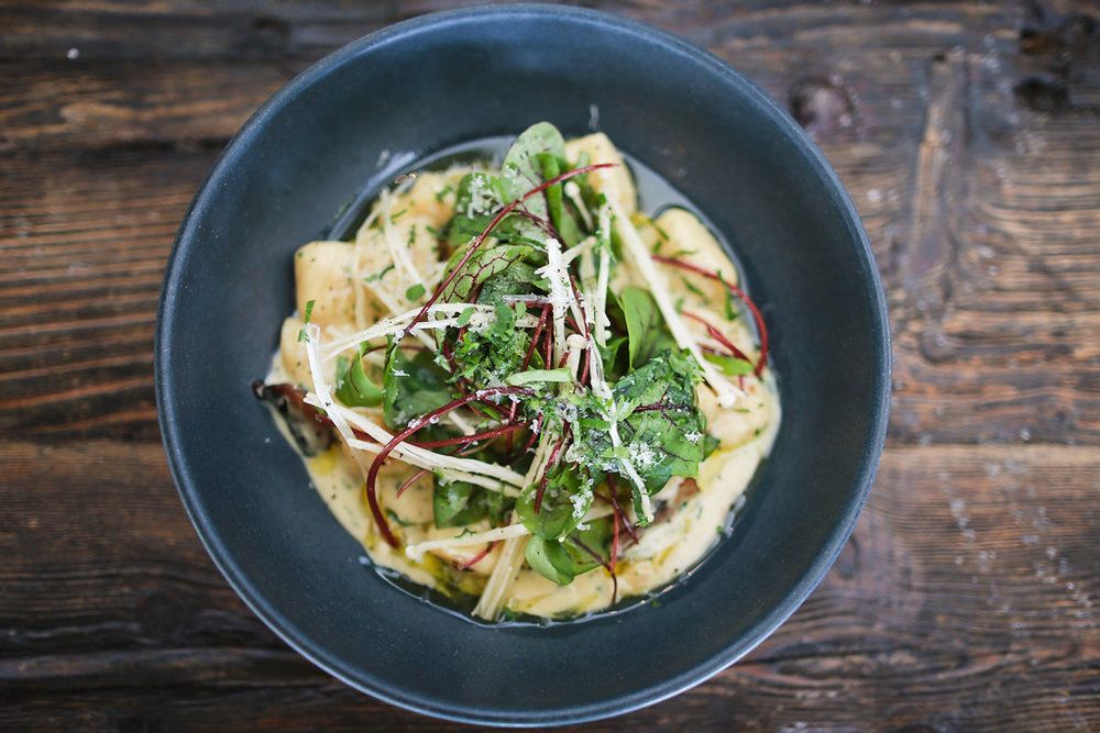 A bowl of food is sitting on a wooden table.