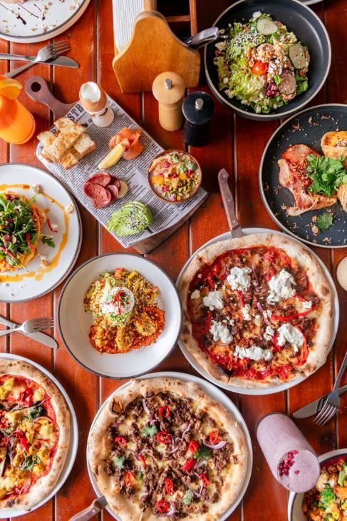 A table spread with pizzas and share plates