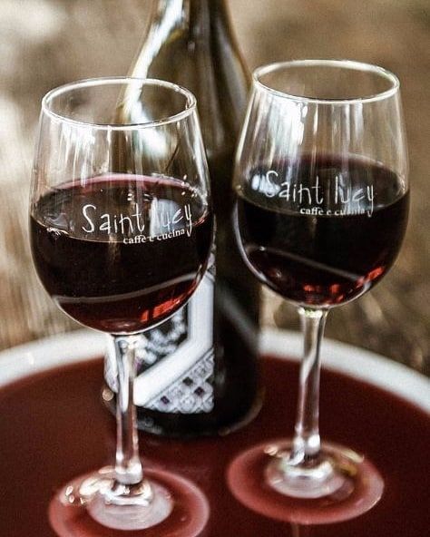 Two glasses of red wine with the word saint on them