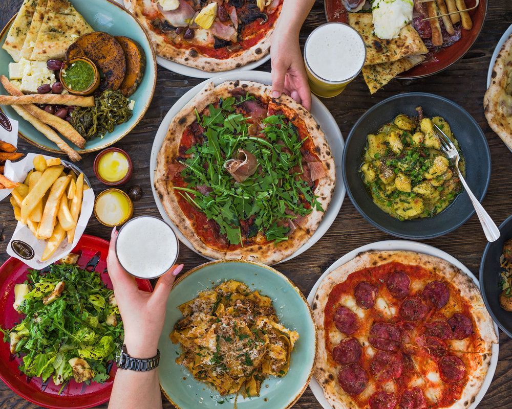 Pizzas, pasta and share plates on a table