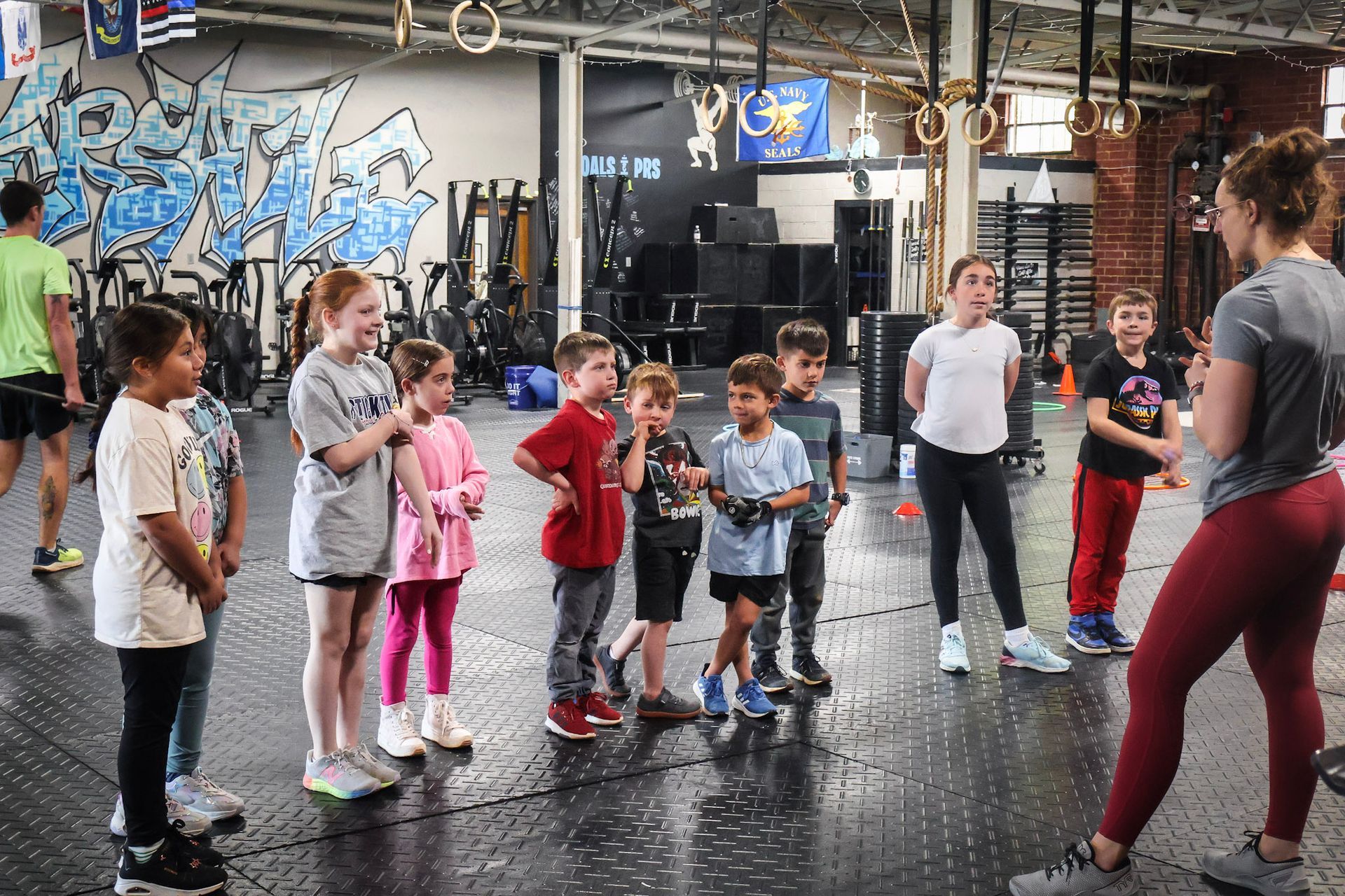 A group of children are standing next to each other in a gym.