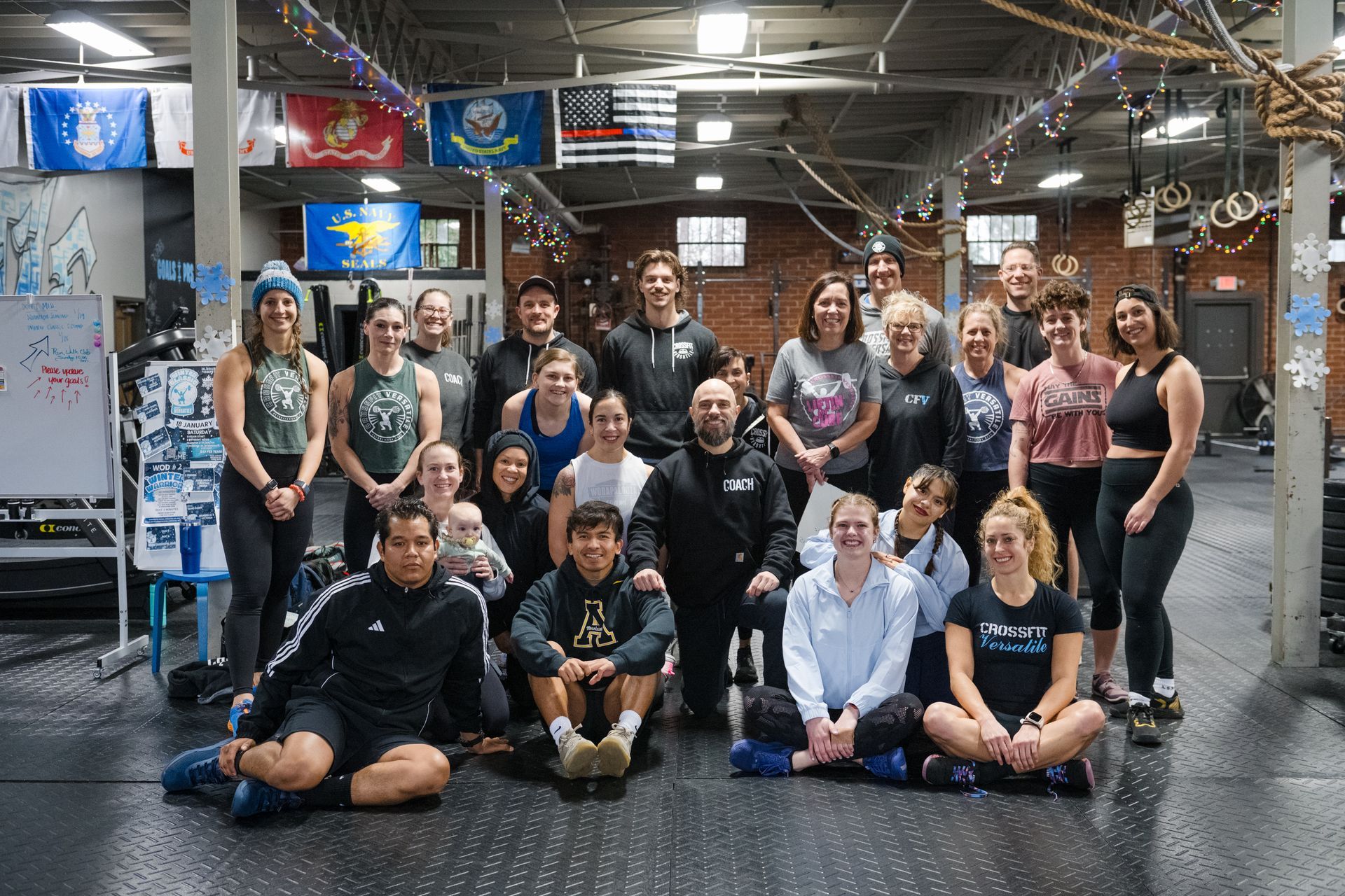 A group of people are posing for a picture in a gym.