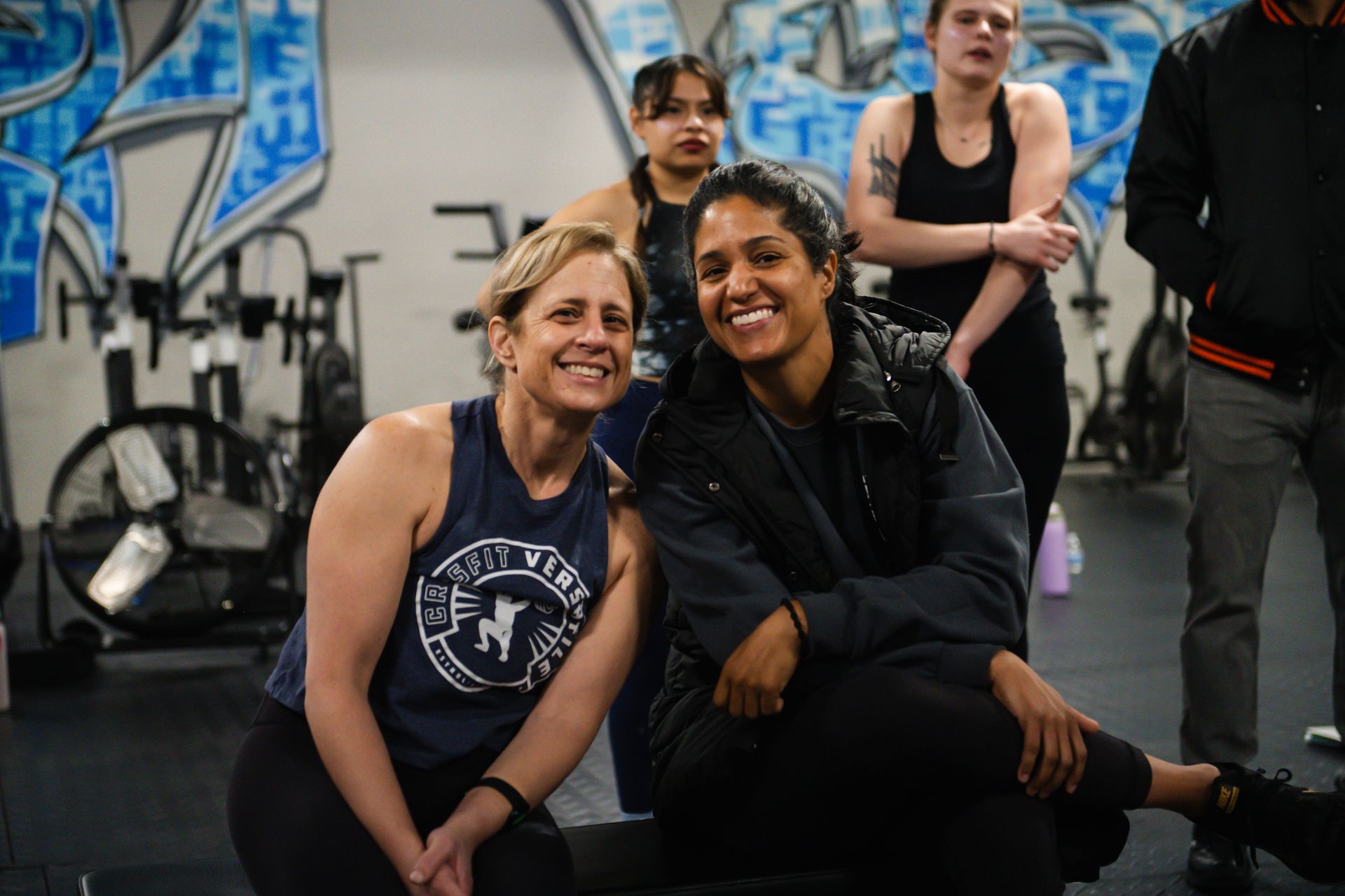 A group of women are posing for a picture in a gym.