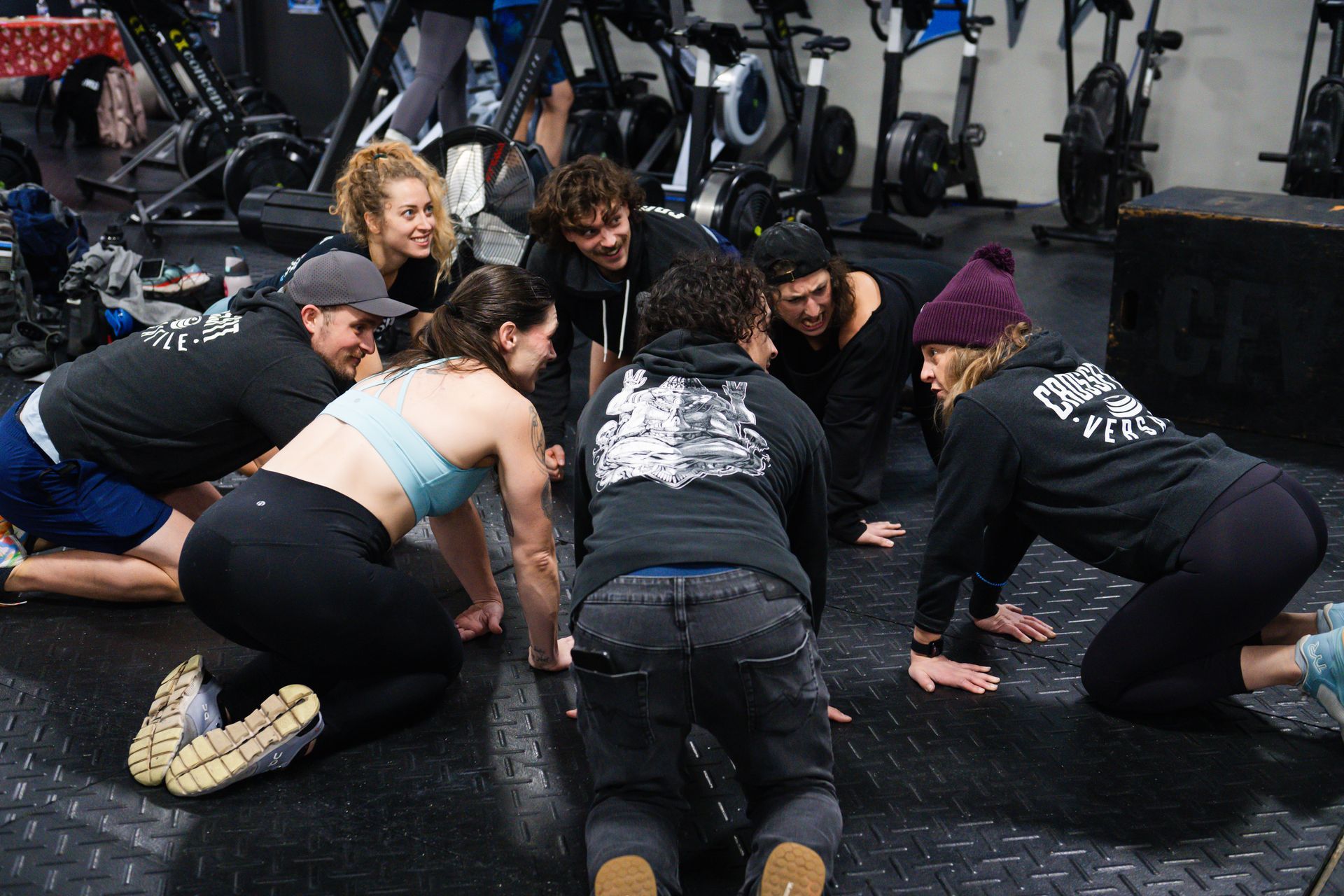 A group of people are doing push ups in a gym.