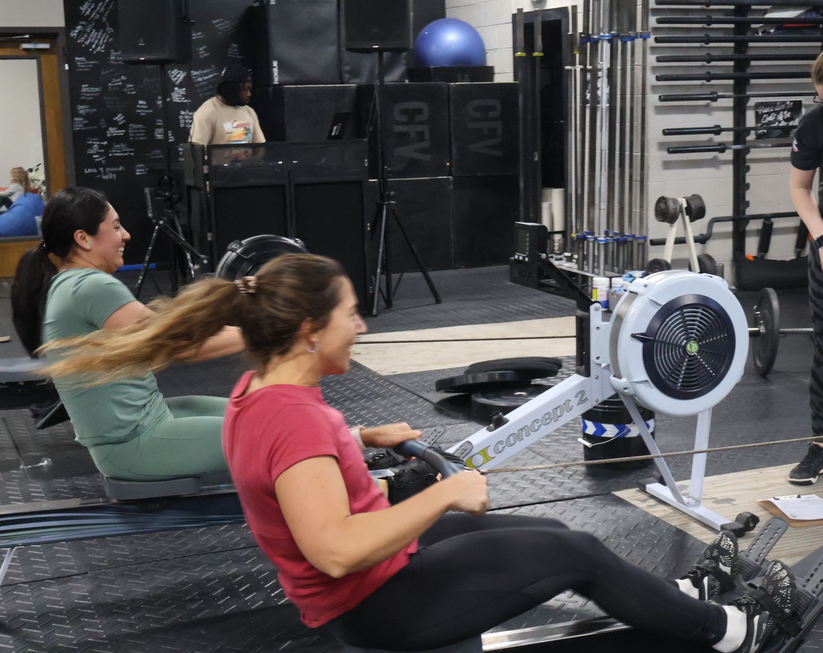 A woman is sitting on a rowing machine in a gym