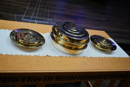 A table with communion trays that says do this in remembrance of me with