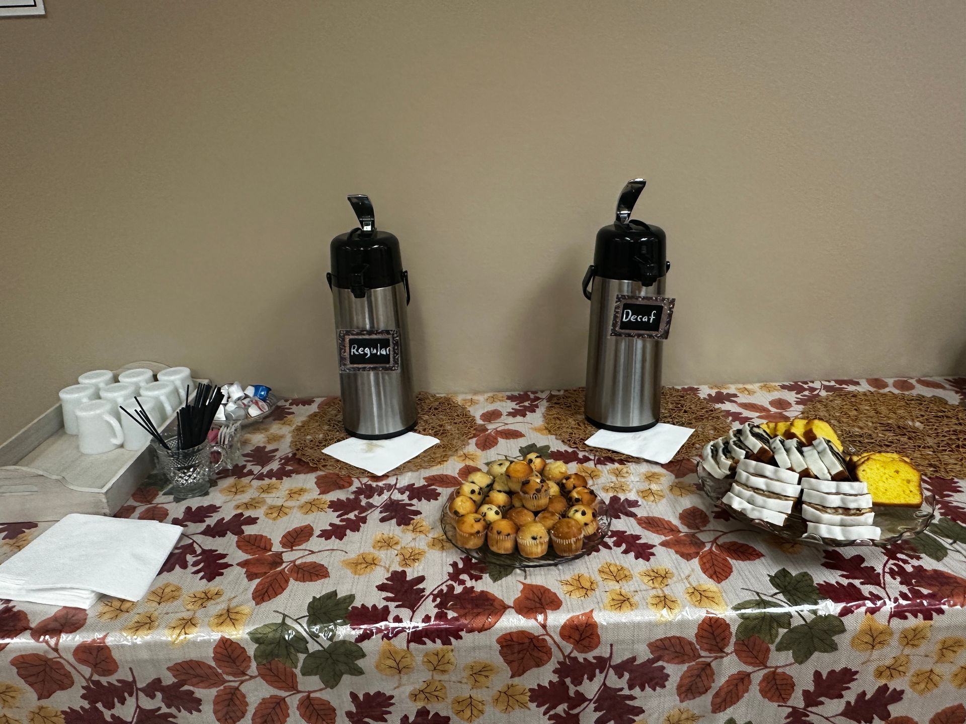 A table with two thermoses and a plate of food on it