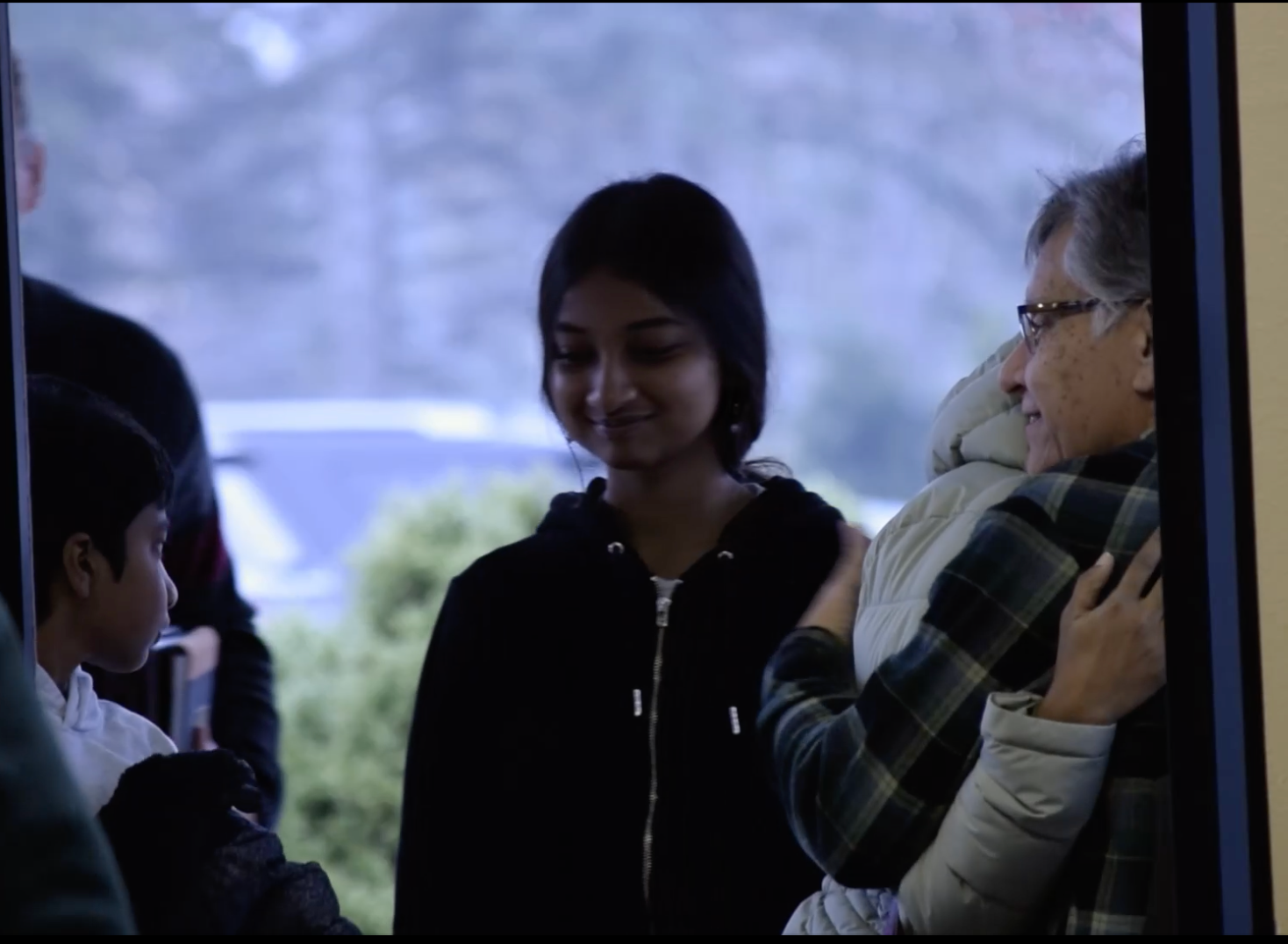A group of people are standing in front of a window