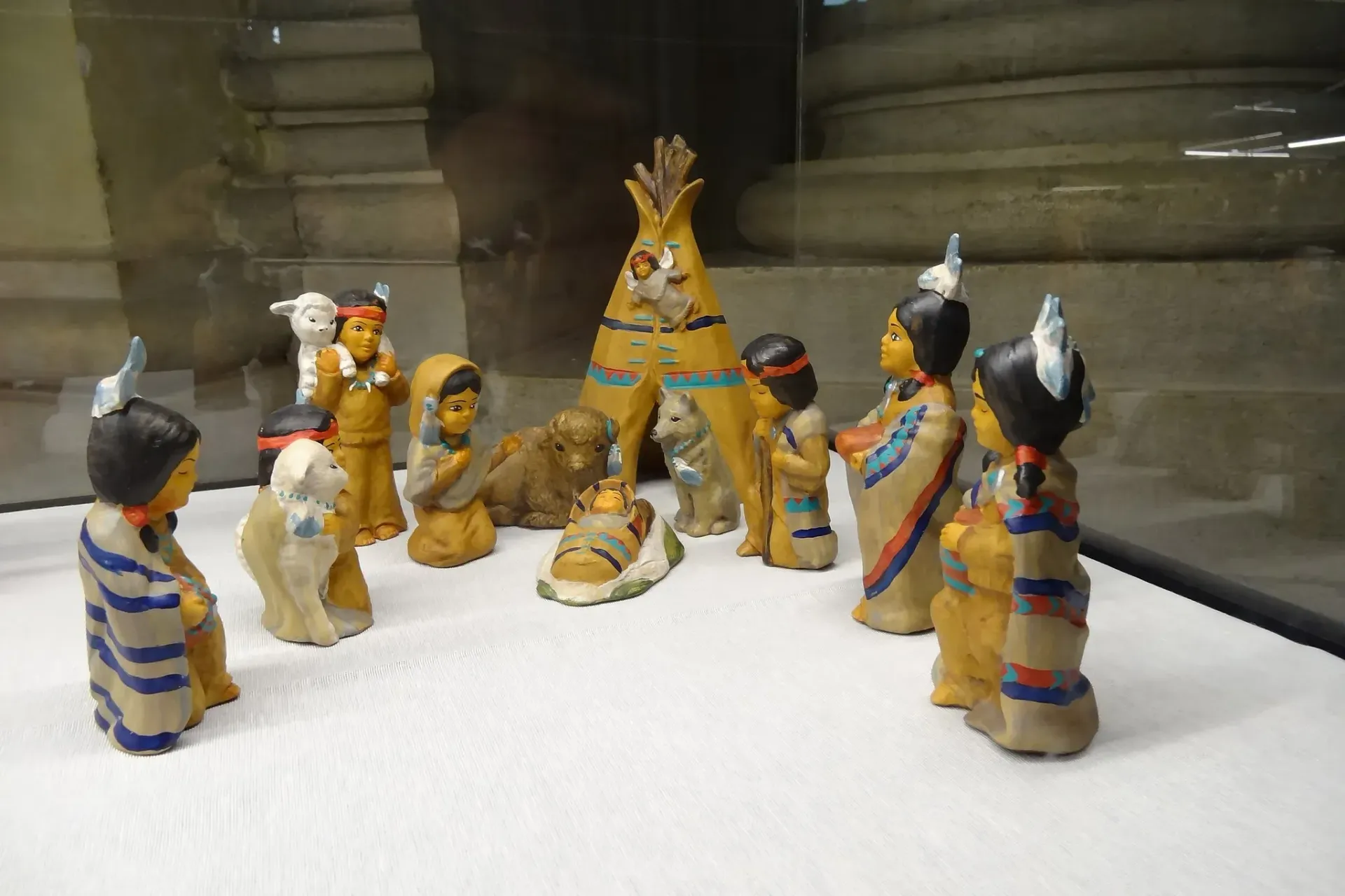 Ceramic Native American figurines around a teepee, on display.