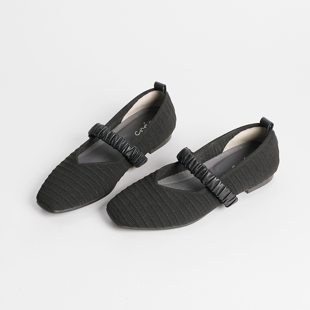 Black Mary Jane style flats with a textured knit upper and ruched strap.