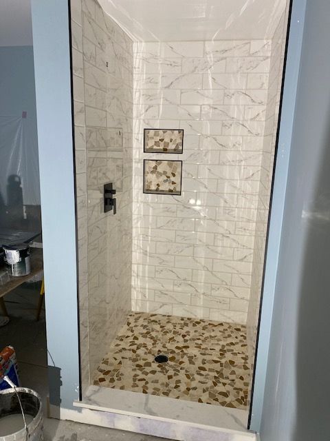A bathroom with a tub , sink and mirror.